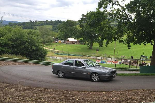 Classic car driving on country road